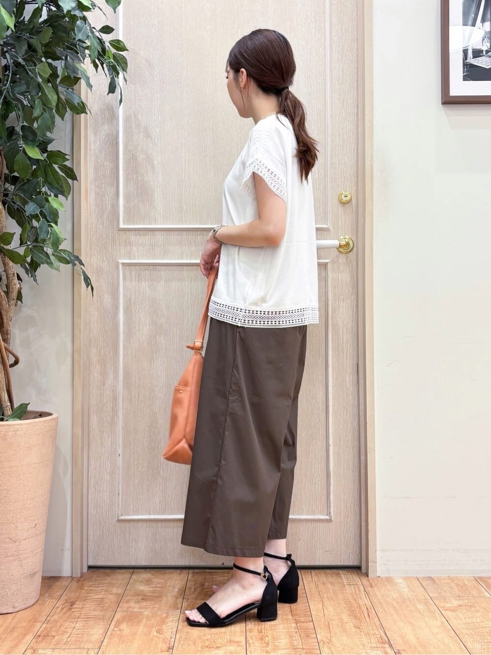 ホワイト系のTシャツ/カットソー、ブラウン系のその他パンツ、ブラック系のサンダルを着用したレディースの夏コーディネートの2枚目の写真