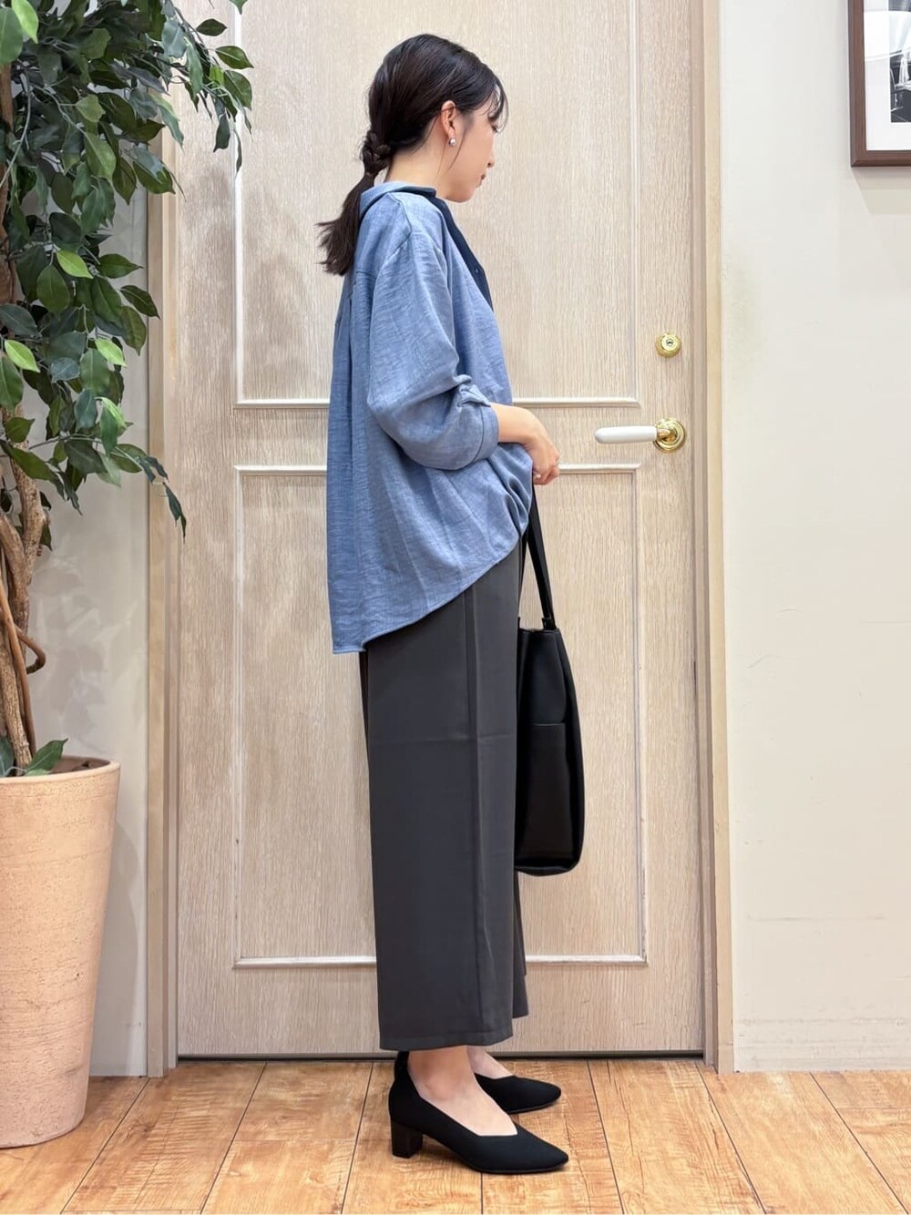 ブルー系のシャツ/ブラウス、グレー系のその他パンツ、ブラック系のパンプスを着用したレディースの秋コーディネートの3枚目の写真
