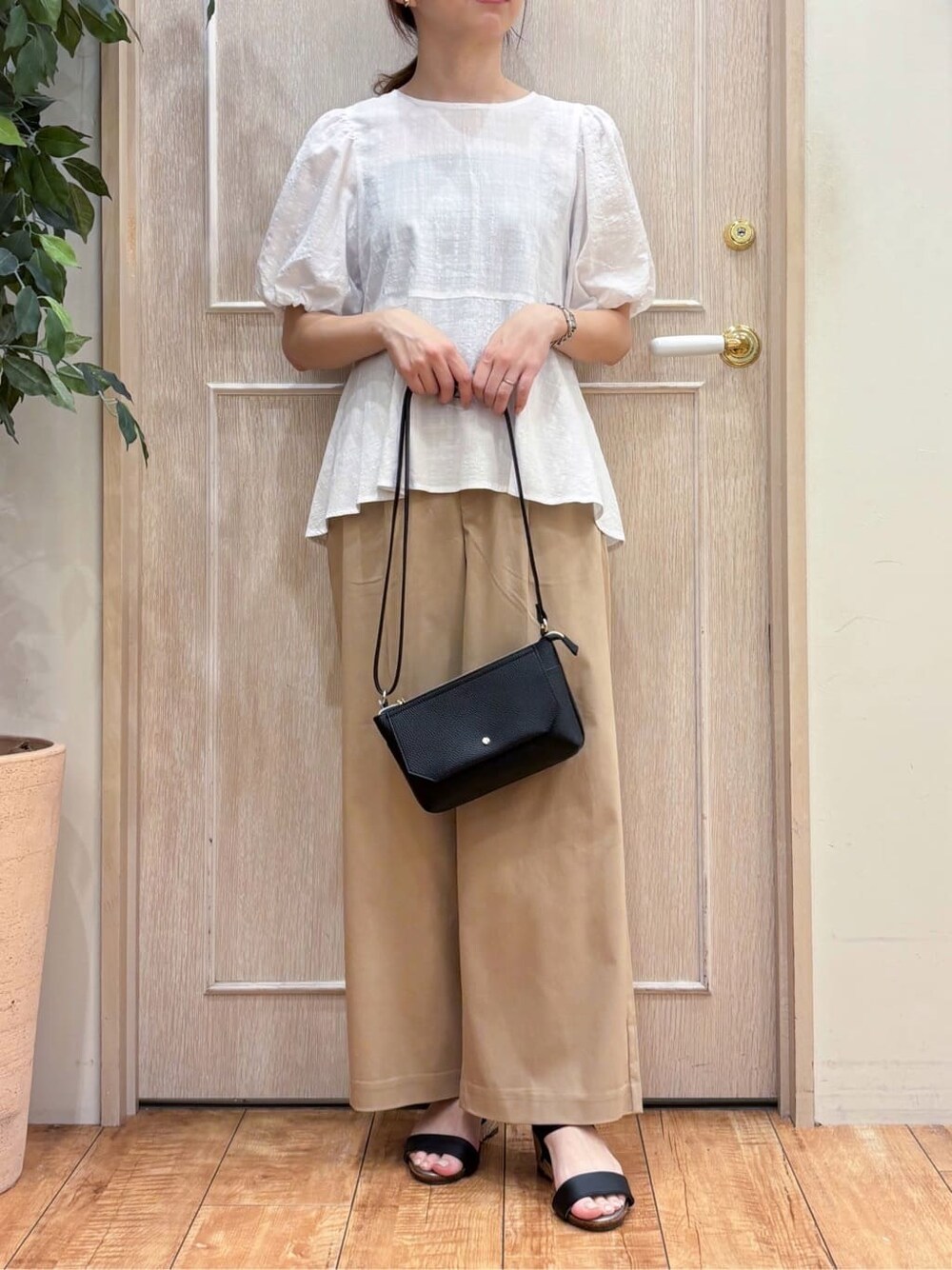 ホワイト系のシャツ/ブラウス、ベージュ系のその他パンツ、ブラック系のサンダルを着用したレディースの夏コーディネートの5枚目の写真