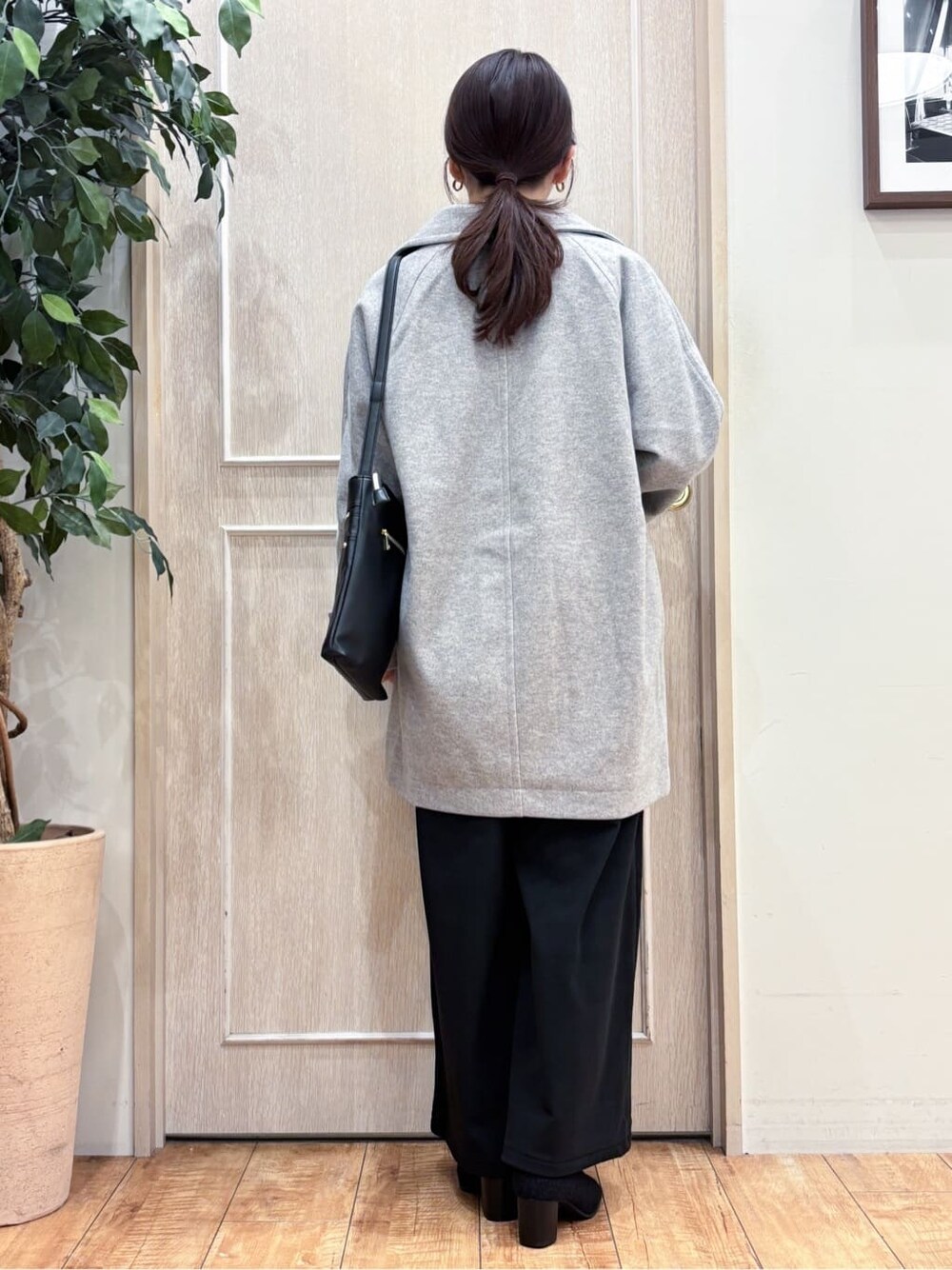 グレー系のチェスターコート、ブルー系のニット/セーター、ブラック系のその他パンツを着用したレディースの冬コーディネートの4枚目の写真
