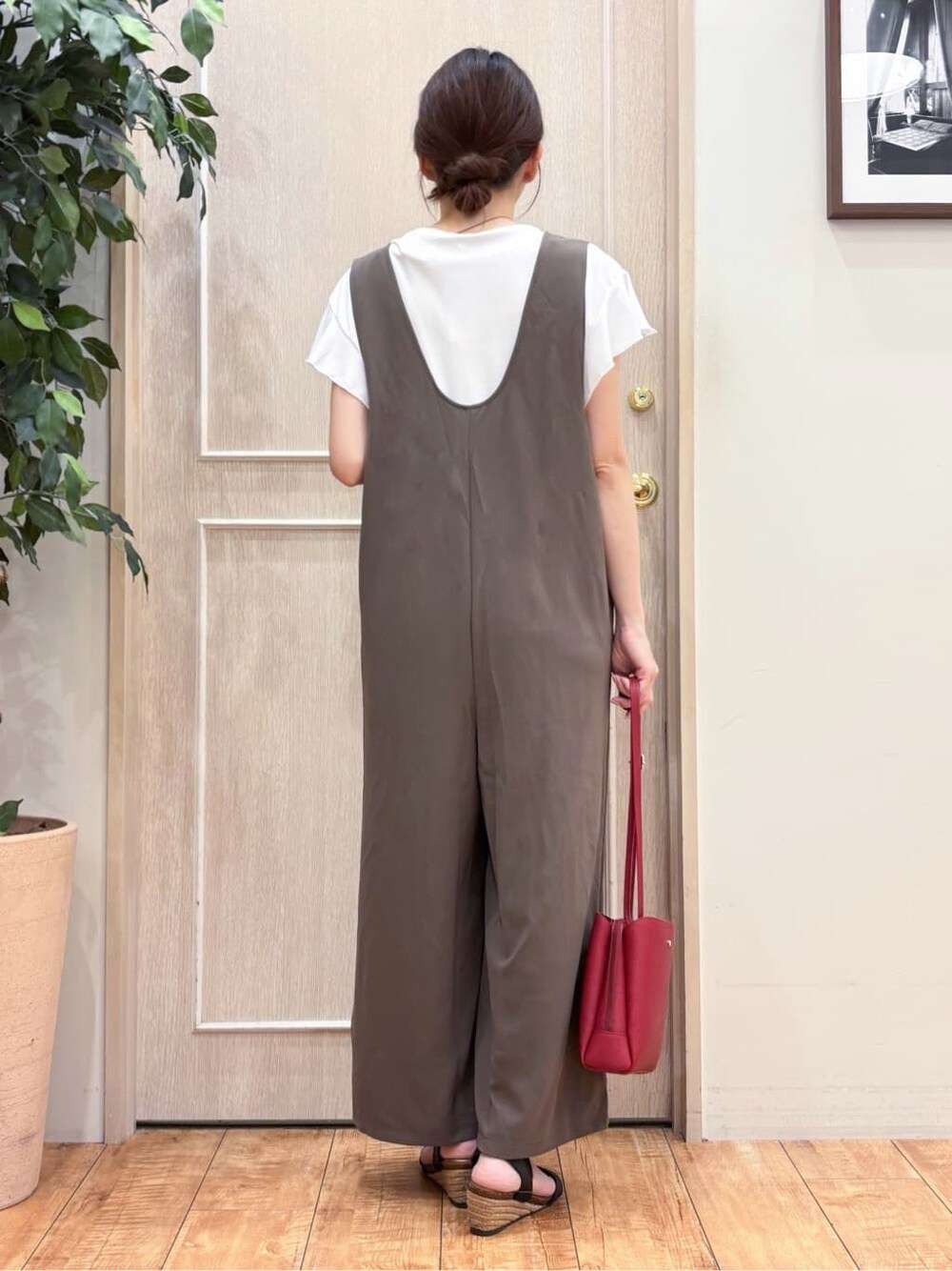 ブラウン系のサロペット/オーバーオール、ホワイト系のTシャツ/カットソー、ブラック系のサンダルを着用したレディースの夏コーディネートの3枚目の写真