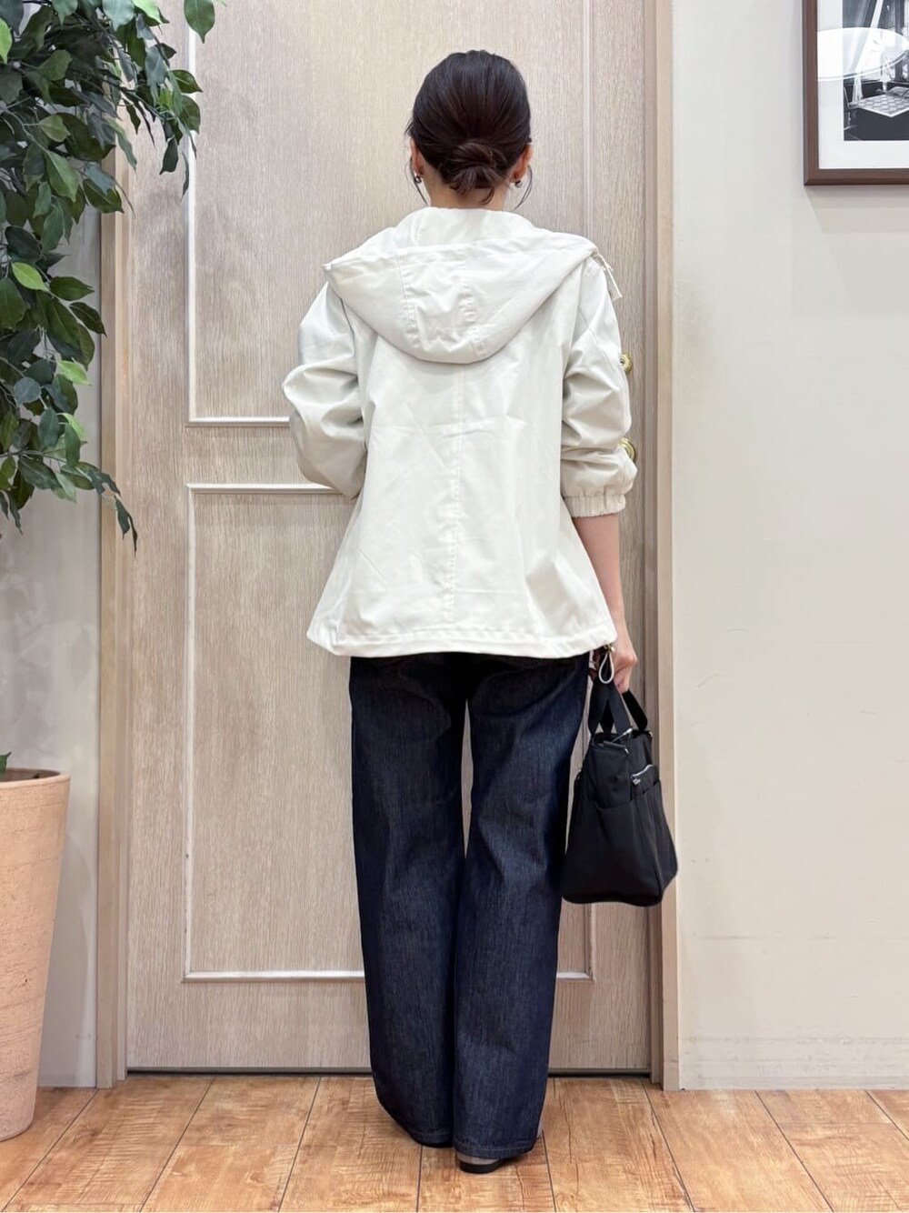 ホワイト系のブルゾン、グリーン系のTシャツ/カットソー、ブルー系のデニムパンツを着用したレディースの冬コーディネートの3枚目の写真