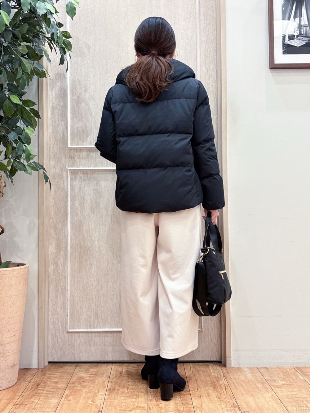 ブラック系のダウンジャケット/コート、グレー系のニット/セーター、ホワイト系のその他パンツを着用したレディースの冬コーディネートの4枚目の写真