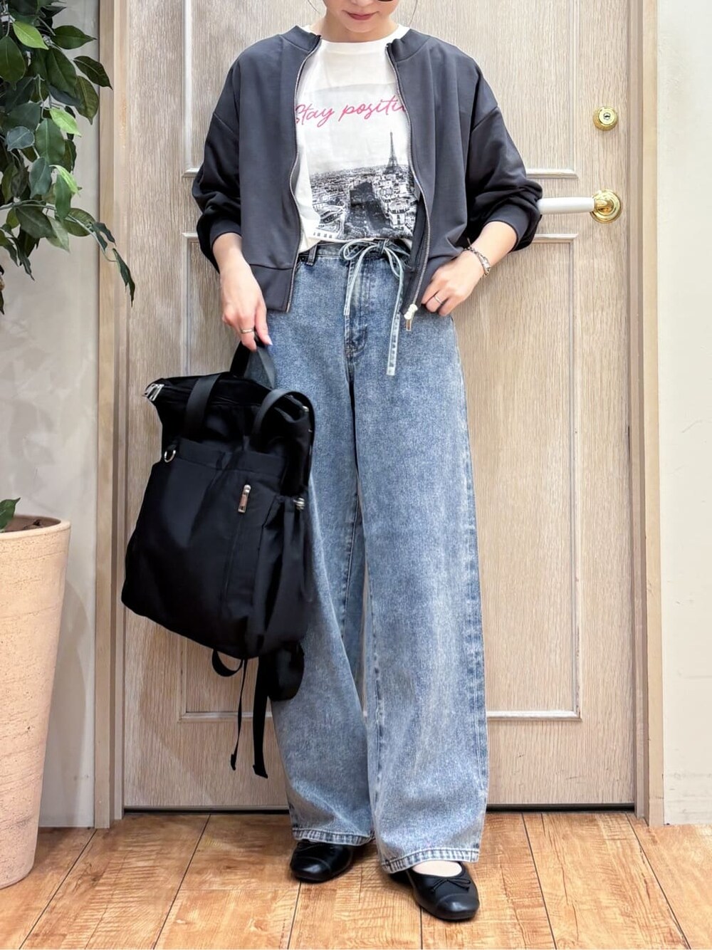 グレー系のカーディガン/ボレロ、ホワイト系のTシャツ/カットソー、ブルー系のデニムパンツを着用したレディースの秋コーディネートの4枚目の写真
