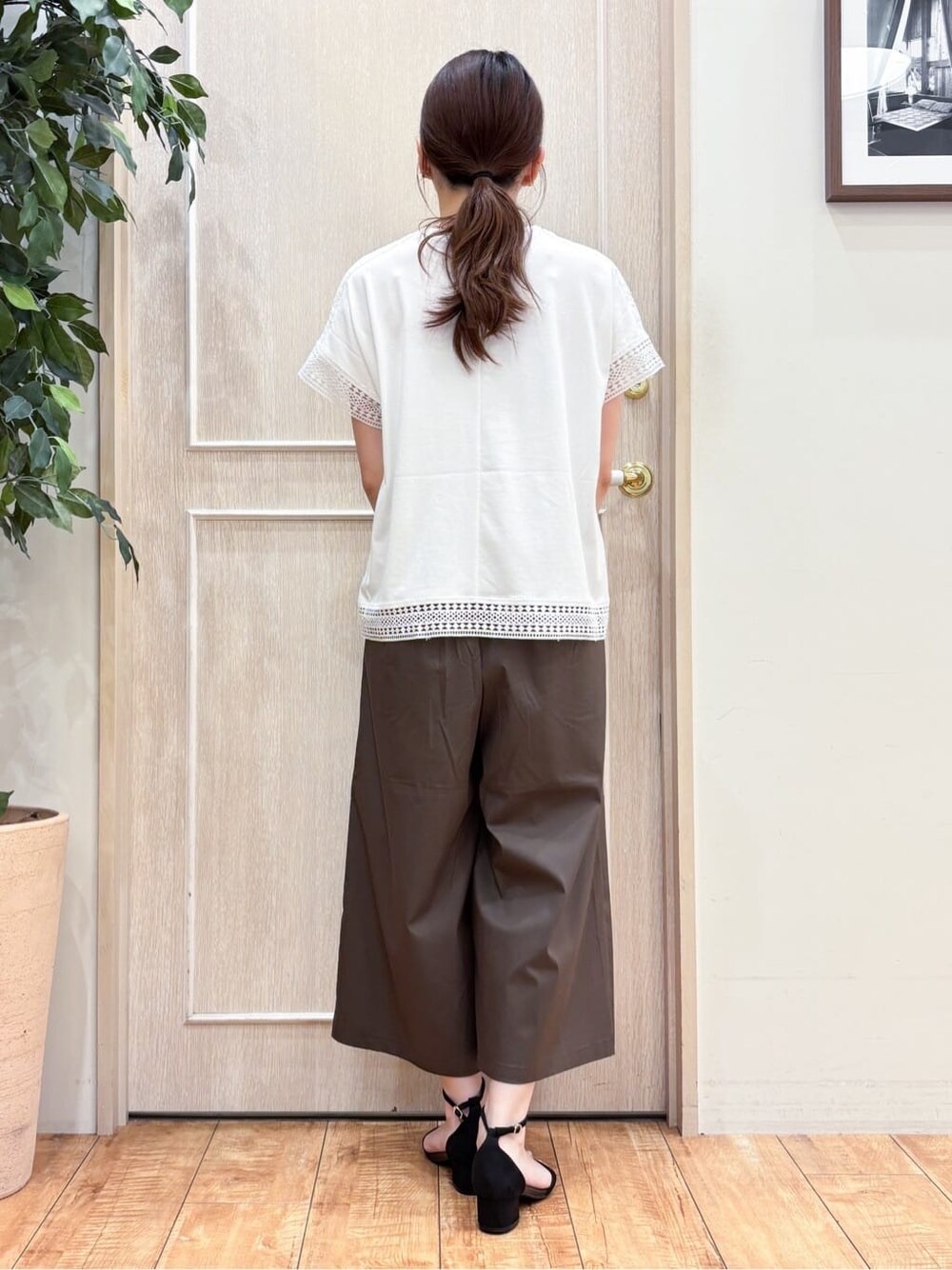 ホワイト系のTシャツ/カットソー、ブラウン系のその他パンツ、ブラック系のサンダルを着用したレディースの夏コーディネートの3枚目の写真