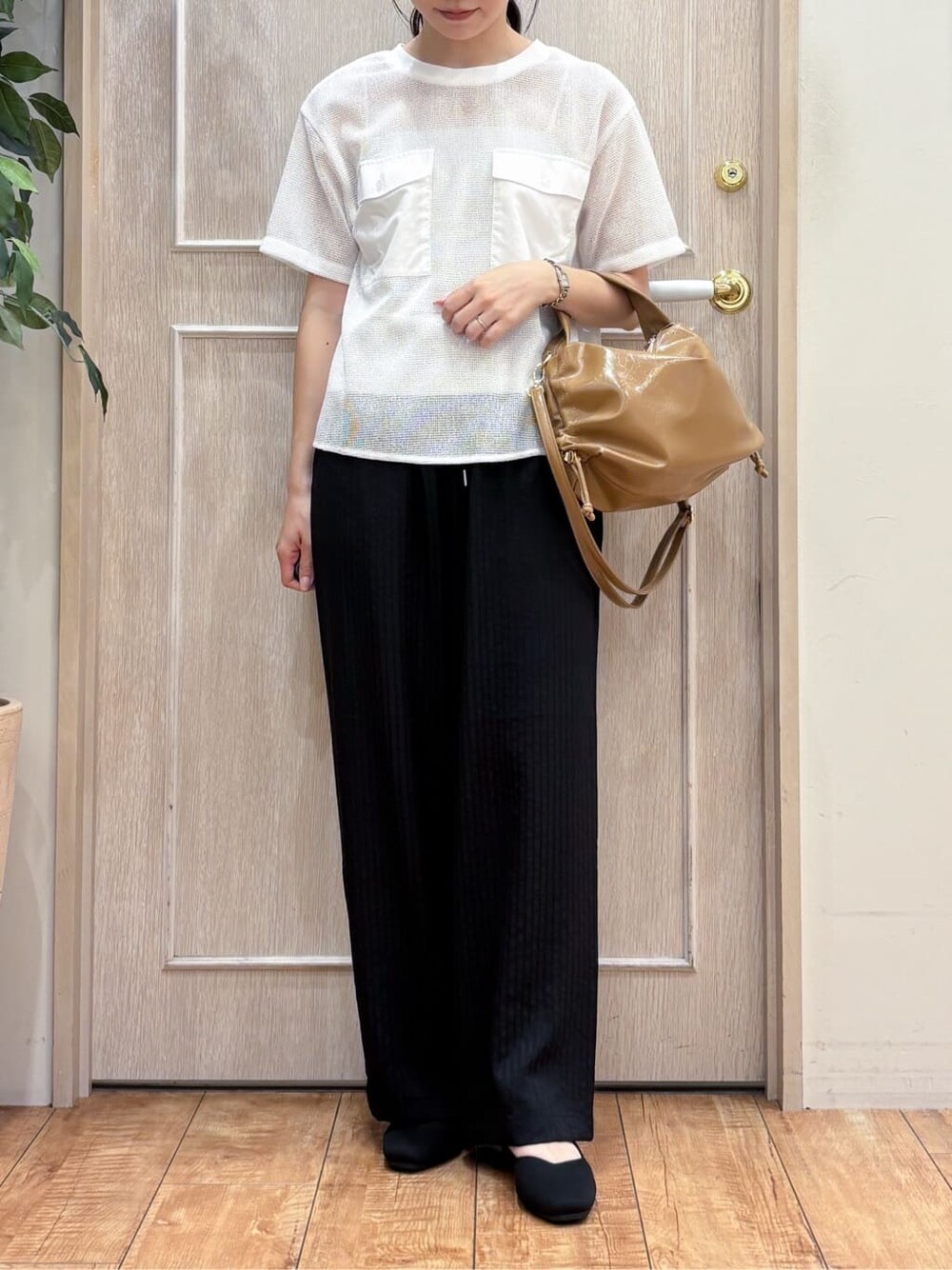 ホワイト系のTシャツ/カットソー、ブラック系のその他パンツ、ブラック系のパンプスを着用したレディースの秋コーディネートの4枚目の写真