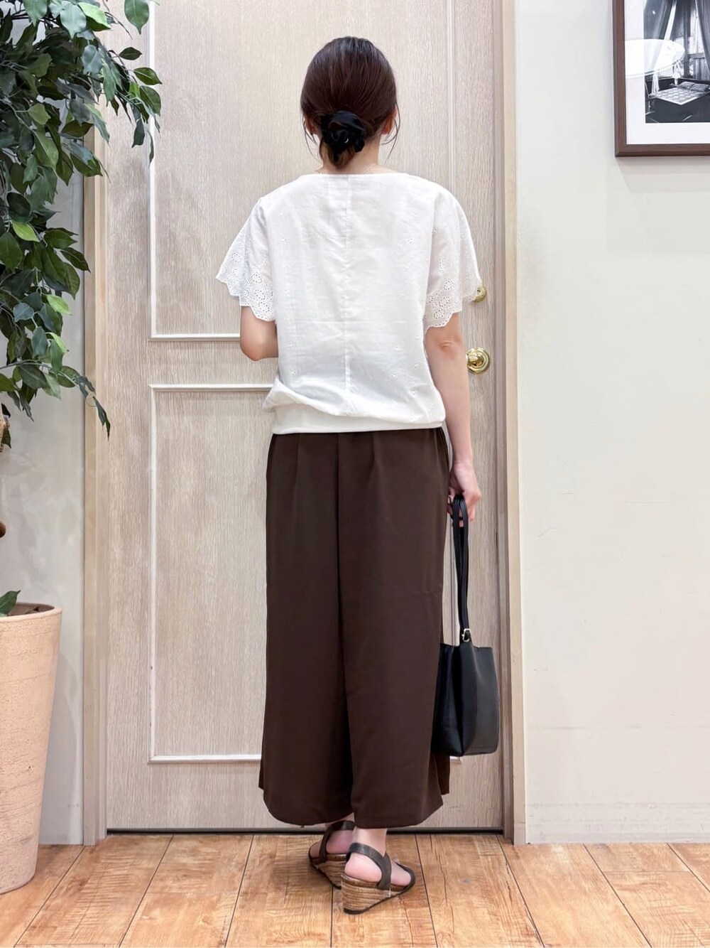 ホワイト系のTシャツ/カットソー、ブラウン系のその他パンツ、その他のサンダルを着用したレディースの夏コーディネートの3枚目の写真