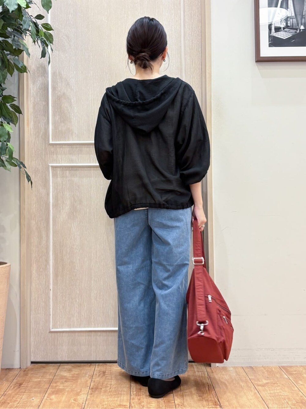 ブラック系のブルゾン、ベージュ系のTシャツ/カットソー、ブルー系のデニムパンツを着用したレディースの秋コーディネートの4枚目の写真