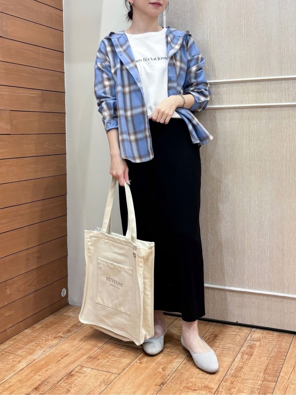ブラック系のスカート、ブルー系のシャツ/ブラウス、ホワイト系のトートバッグを着用したレディースの春コーディネートの5枚目の写真
