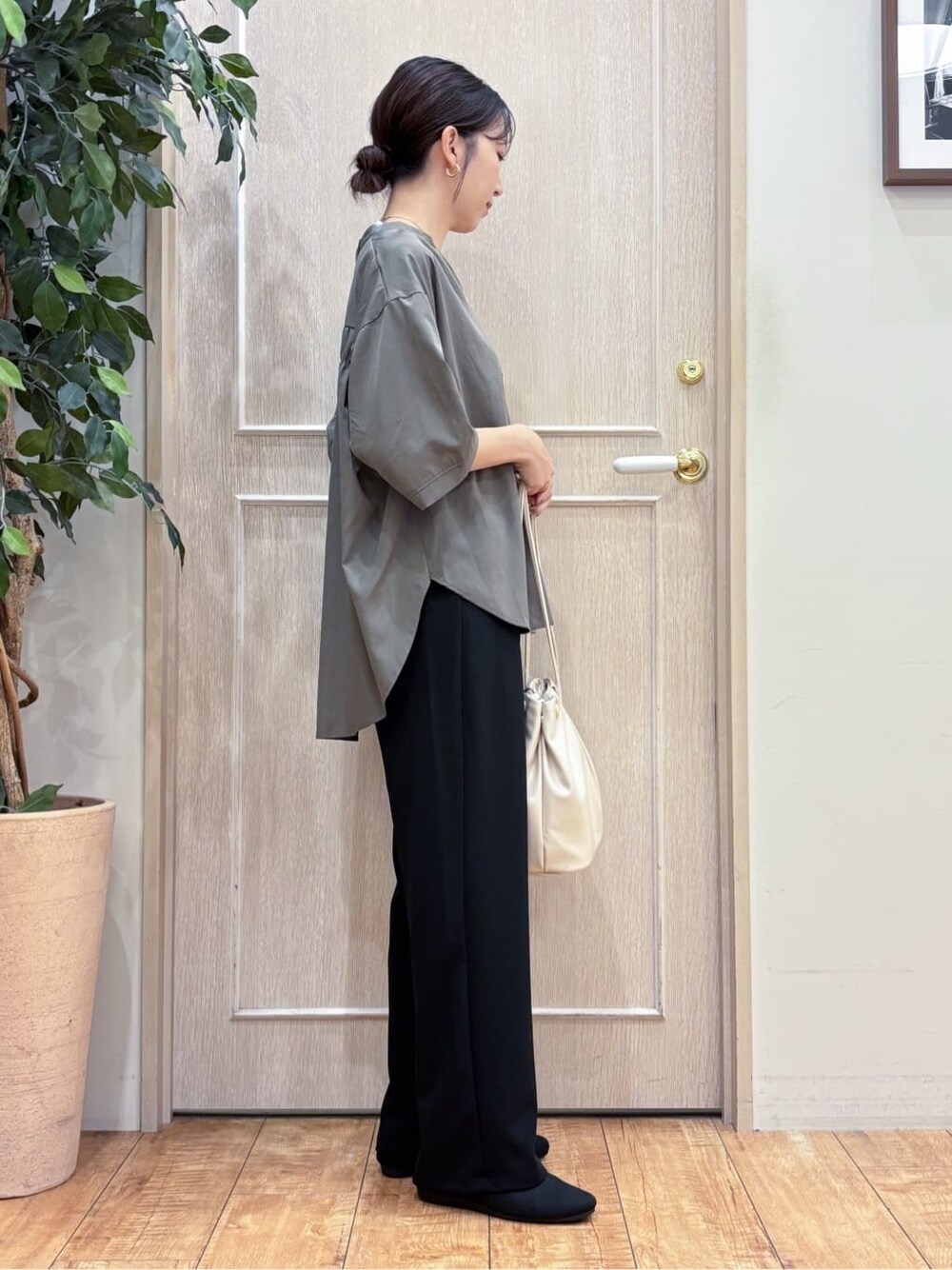 グリーン系のシャツ/ブラウス、ブラック系のその他パンツ、ブラック系のパンプスを着用したレディースの秋コーディネートの2枚目の写真
