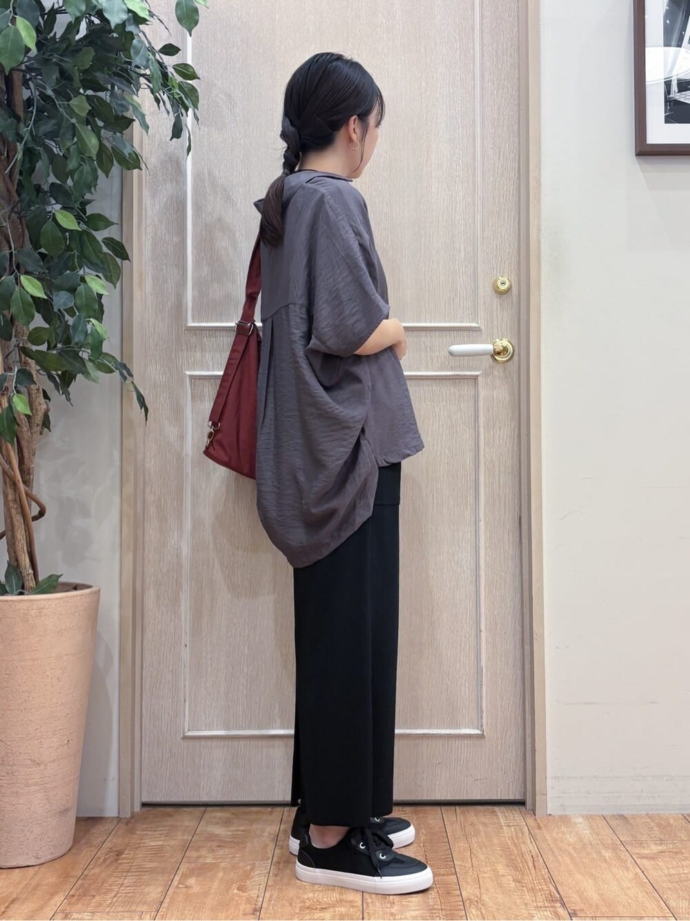ブラウン系のシャツ/ブラウス、ホワイト系のTシャツ/カットソー、ブラック系のスカートを着用したレディースの秋コーディネートの2枚目の写真