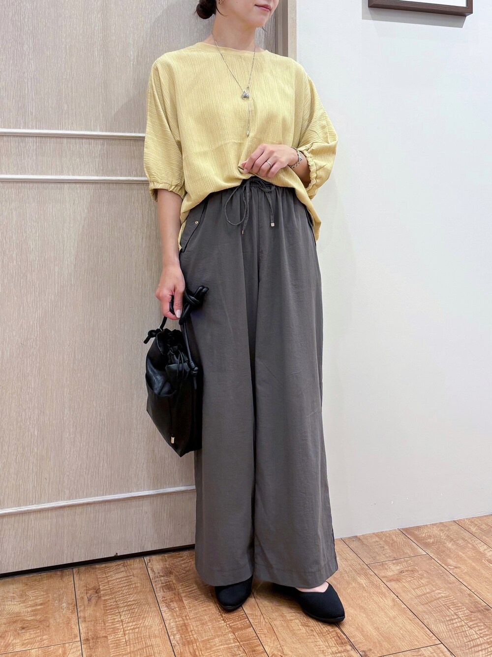 イエロー系のシャツ/ブラウス、ブラウン系のその他パンツ、ブラック系のパンプスを着用したレディースの夏コーディネートの5枚目の写真