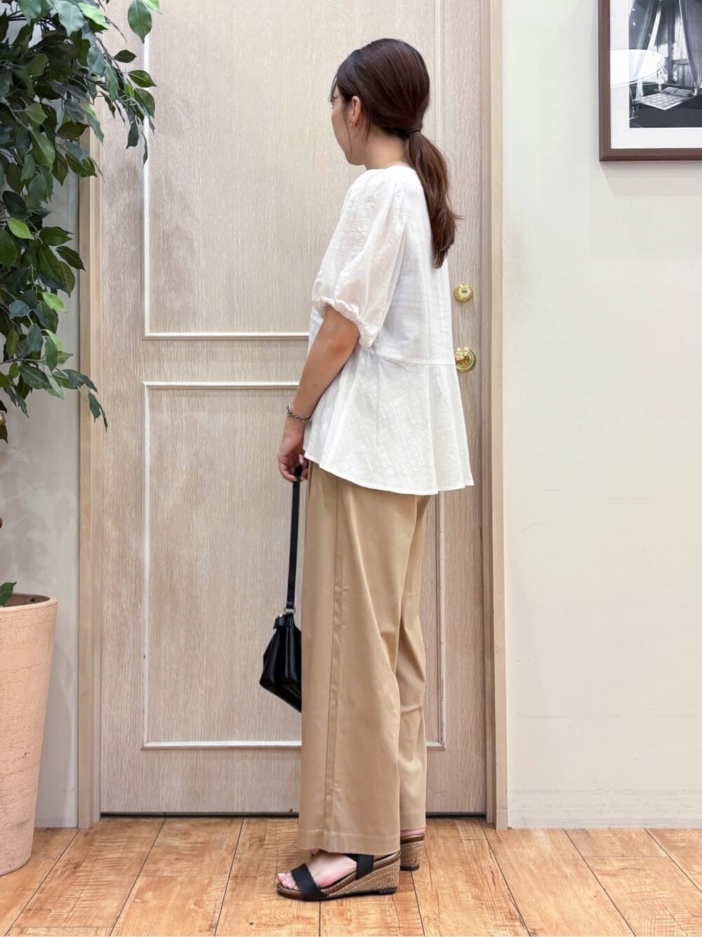 ホワイト系のシャツ/ブラウス、ベージュ系のその他パンツ、ブラック系のサンダルを着用したレディースの夏コーディネートの3枚目の写真