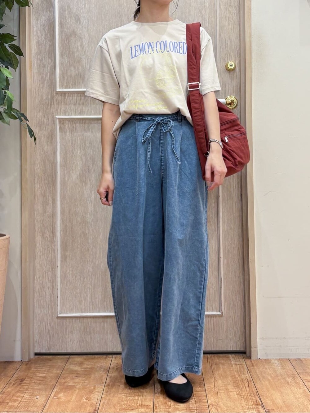 ブラック系のブルゾン、ベージュ系のTシャツ/カットソー、ブルー系のデニムパンツを着用したレディースの秋コーディネートの5枚目の写真