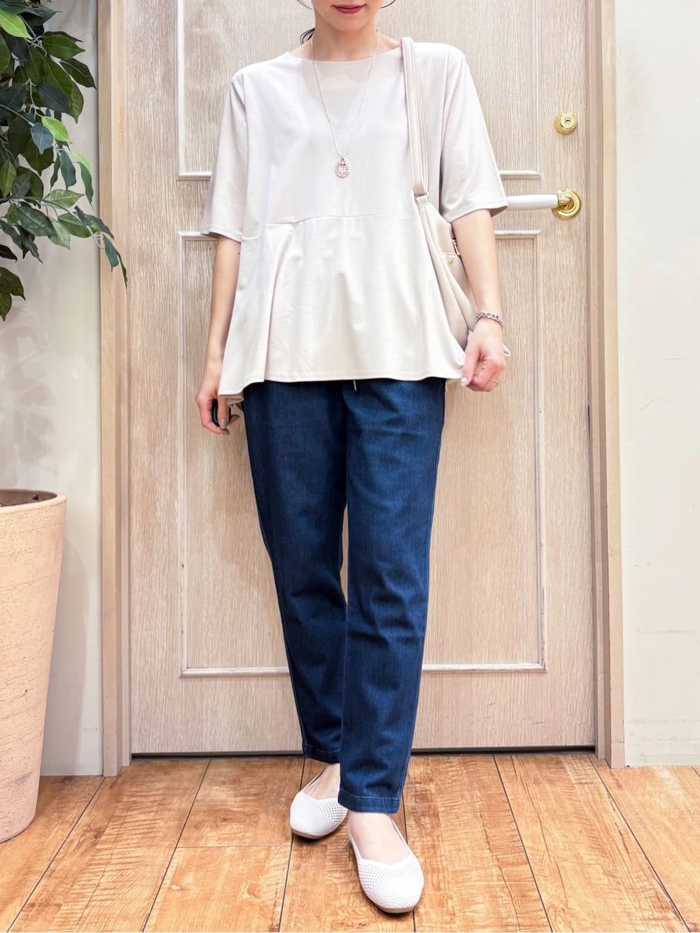 オレンジ系のカーディガン/ボレロ、ベージュ系のTシャツ/カットソー、ブルー系のその他パンツを着用したレディースの春コーディネートの4枚目の写真