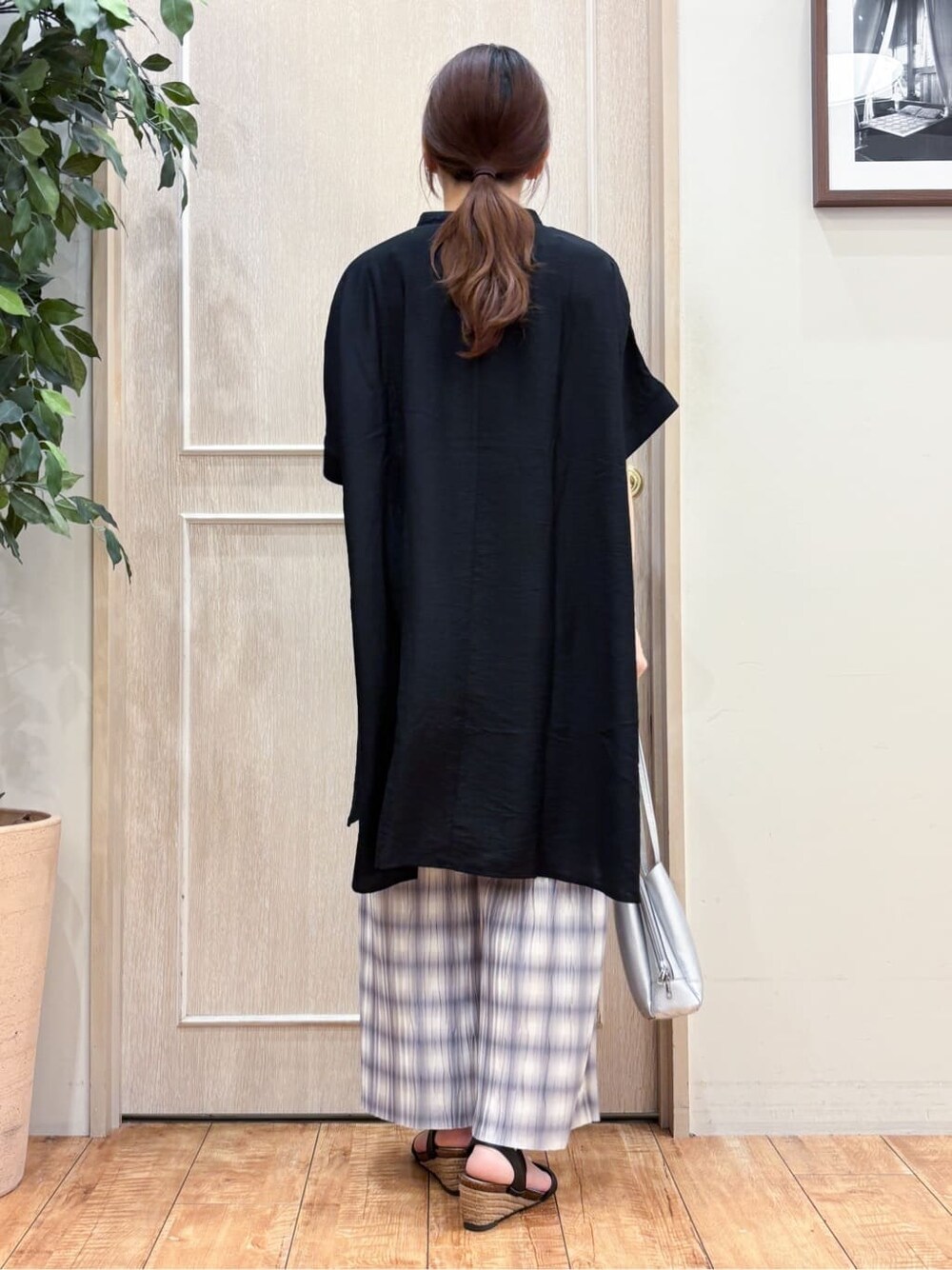 ブラック系のチュニック、グレー系のその他パンツ、ブラック系のサンダルを着用したレディースの夏コーディネートの3枚目の写真