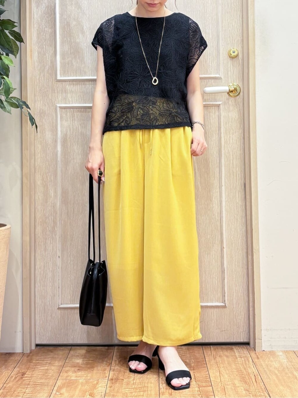 ブラック系のその他トップス、イエロー系のその他パンツ、ブラック系のサンダルを着用したレディースの夏コーディネートの4枚目の写真