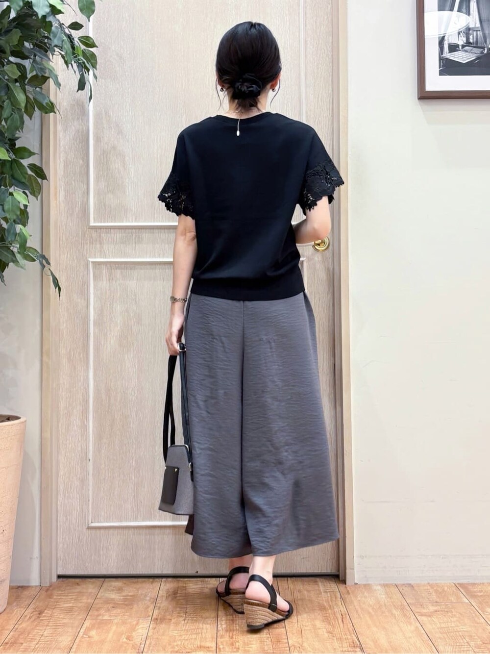 ブラック系のニット/セーター、グレー系のその他パンツ、ブラック系のサンダルを着用したレディースの夏コーディネートの3枚目の写真