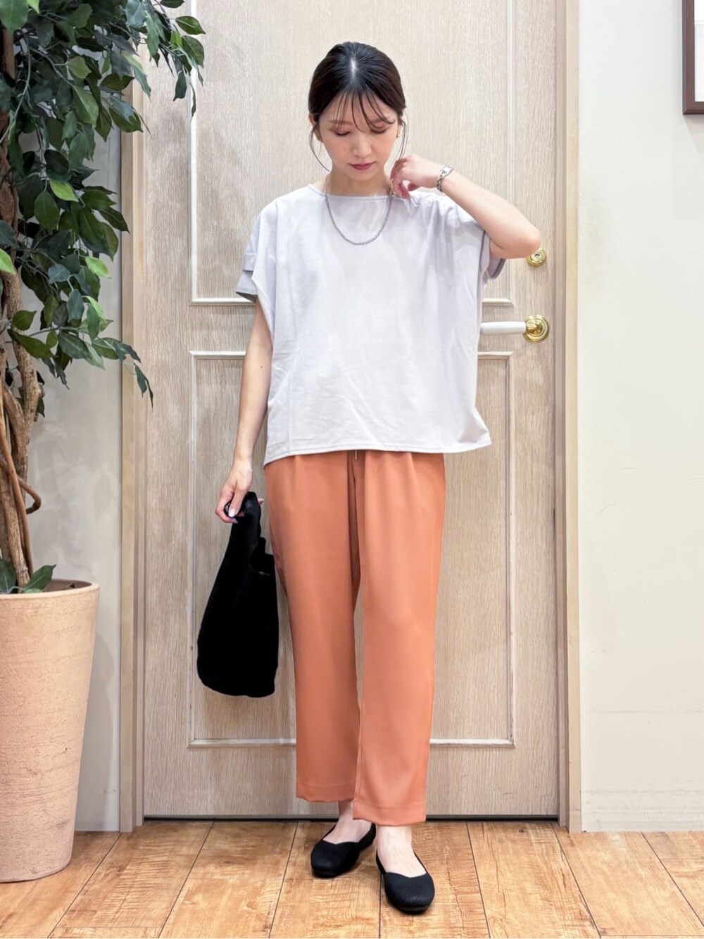 グレー系のTシャツ/カットソー、オレンジ系のその他パンツ、シルバー系のその他シューズを着用したレディースの夏コーディネートの2枚目の写真