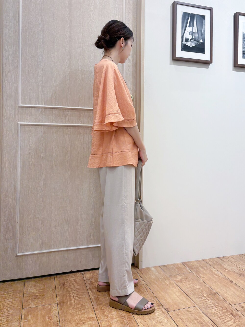 オレンジ系のシャツ/ブラウス、ベージュ系のその他パンツ、ブラウン系のサンダルを着用したレディースの夏コーディネートの3枚目の写真