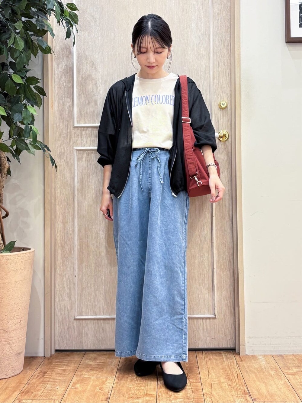 ブラック系のブルゾン、ベージュ系のTシャツ/カットソー、ブルー系のデニムパンツを着用したレディースの秋コーディネートの2枚目の写真