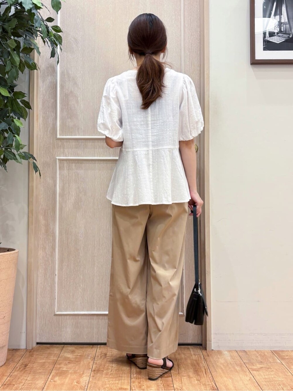ホワイト系のシャツ/ブラウス、ベージュ系のその他パンツ、ブラック系のサンダルを着用したレディースの夏コーディネートの4枚目の写真