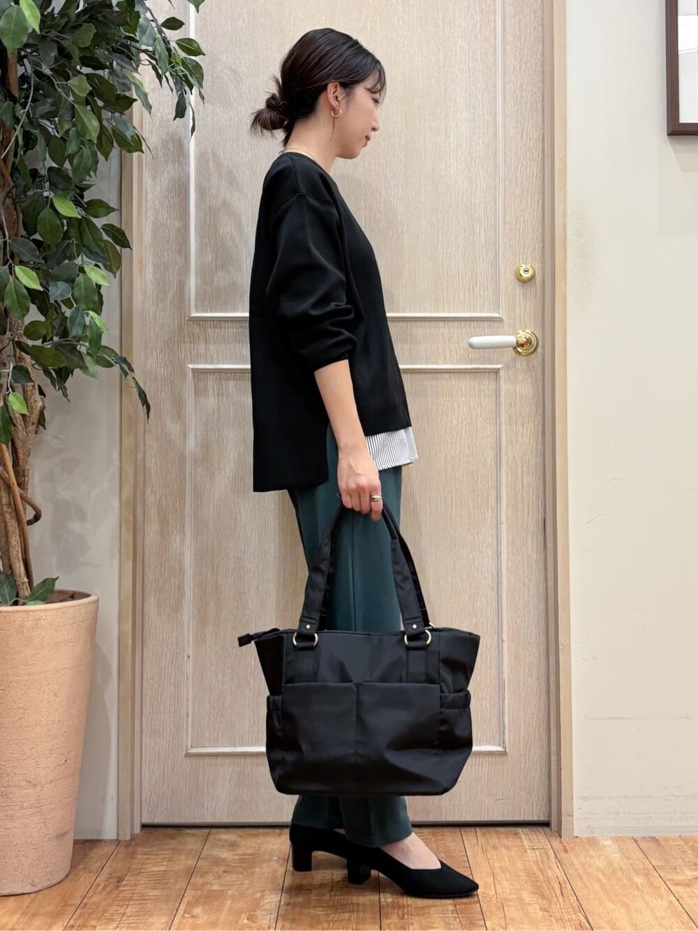 ブラック系のニット/セーター、グリーン系のその他パンツ、ブラック系のパンプスを着用したレディースの秋コーディネートの3枚目の写真