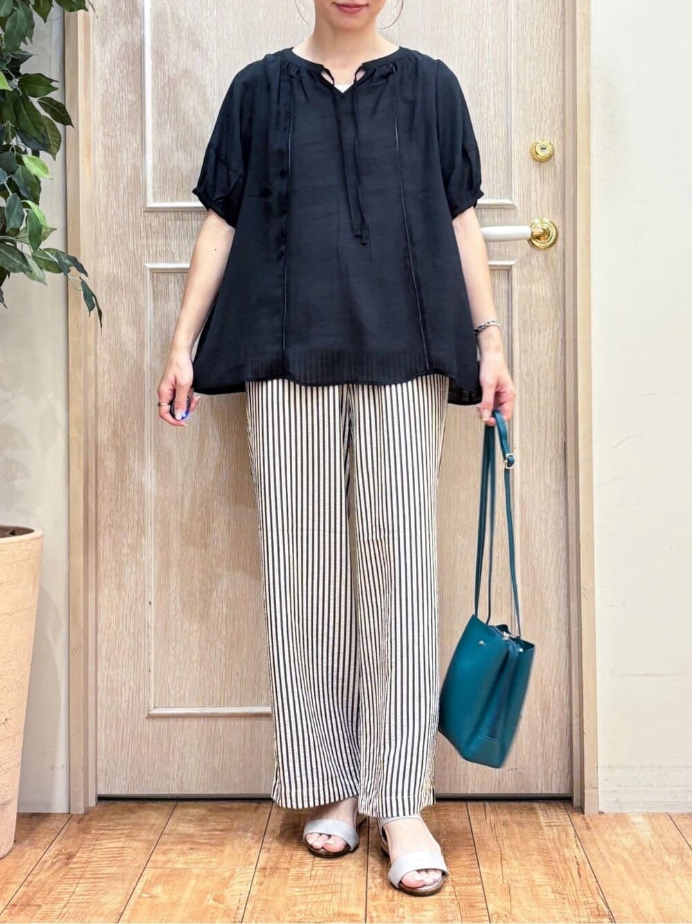 ブラック系のその他トップス、ブルー系のその他パンツ、シルバー系のサンダルを着用したレディースの夏コーディネートの4枚目の写真