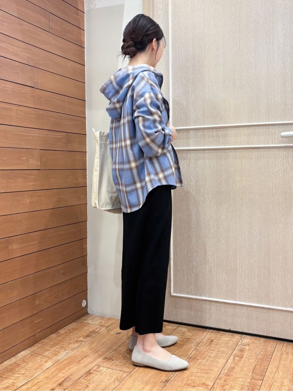 ブラック系のスカート、ブルー系のシャツ/ブラウス、ホワイト系のトートバッグを着用したレディースの春コーディネートの3枚目の写真