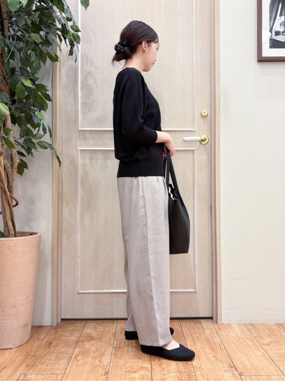 ブラック系のニット/セーター、ベージュ系のその他パンツ、シルバー系のその他シューズを着用したレディースの春コーディネートの2枚目の写真