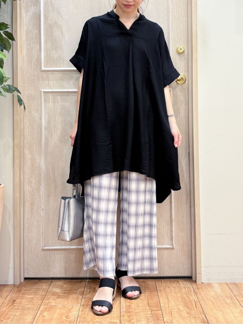 ブラック系のチュニック、グレー系のその他パンツ、ブラック系のサンダルを着用したレディースの夏コーディネートの4枚目の写真