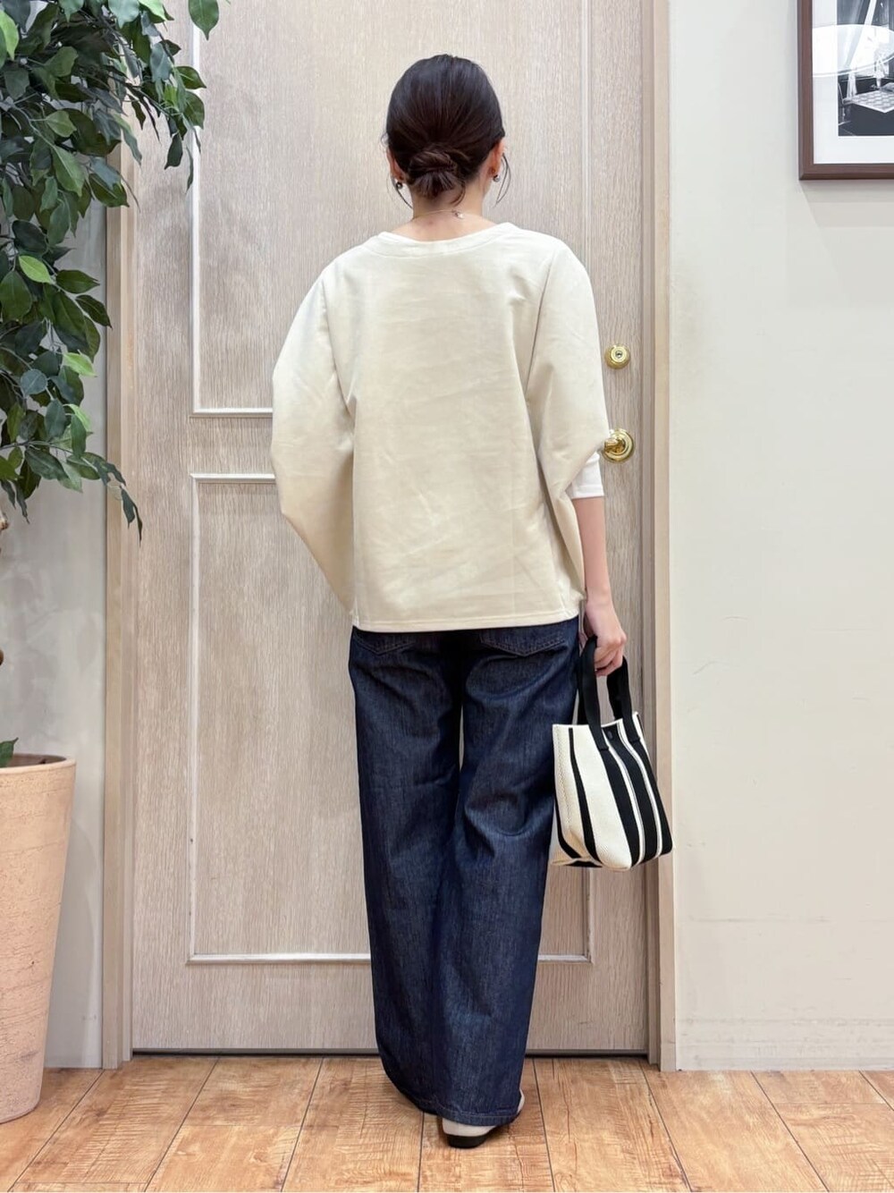 ブルー系のデニムパンツ、ホワイト系のその他トップス、ブラック系のトートバッグを着用したレディースの冬コーディネートの3枚目の写真