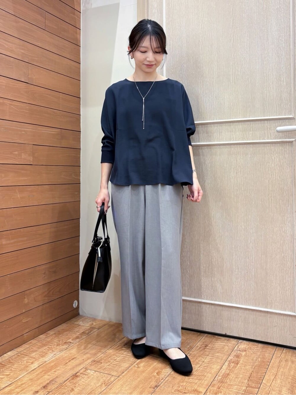 ブルー系のシャツ/ブラウス、グレー系のその他パンツ、ブラック系のパンプスを着用したレディースの春コーディネートの2枚目の写真