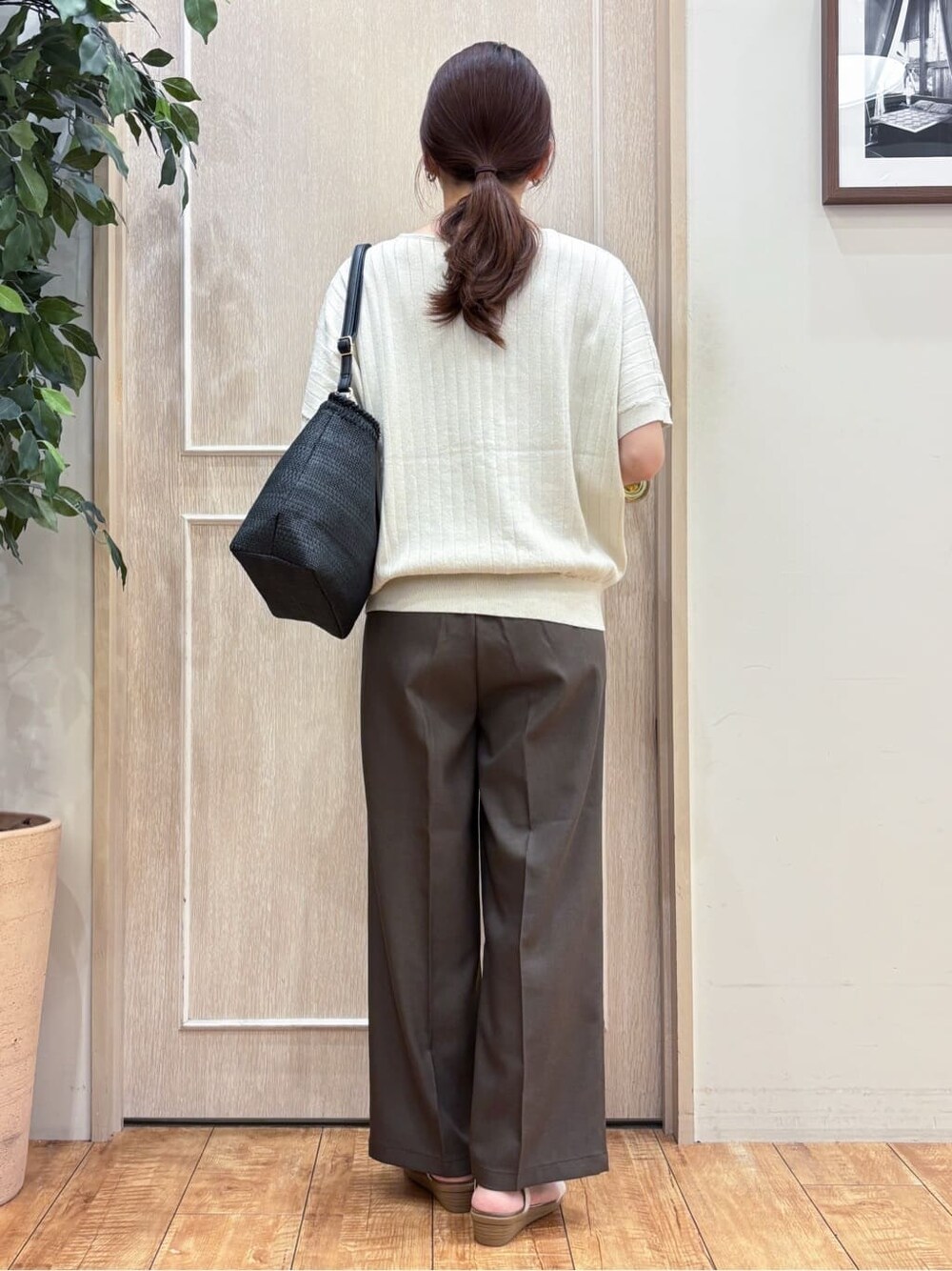 ゴールド系のニット/セーター、ブラウン系のその他パンツ、ゴールド系のサンダルを着用したレディースの夏コーディネートの3枚目の写真