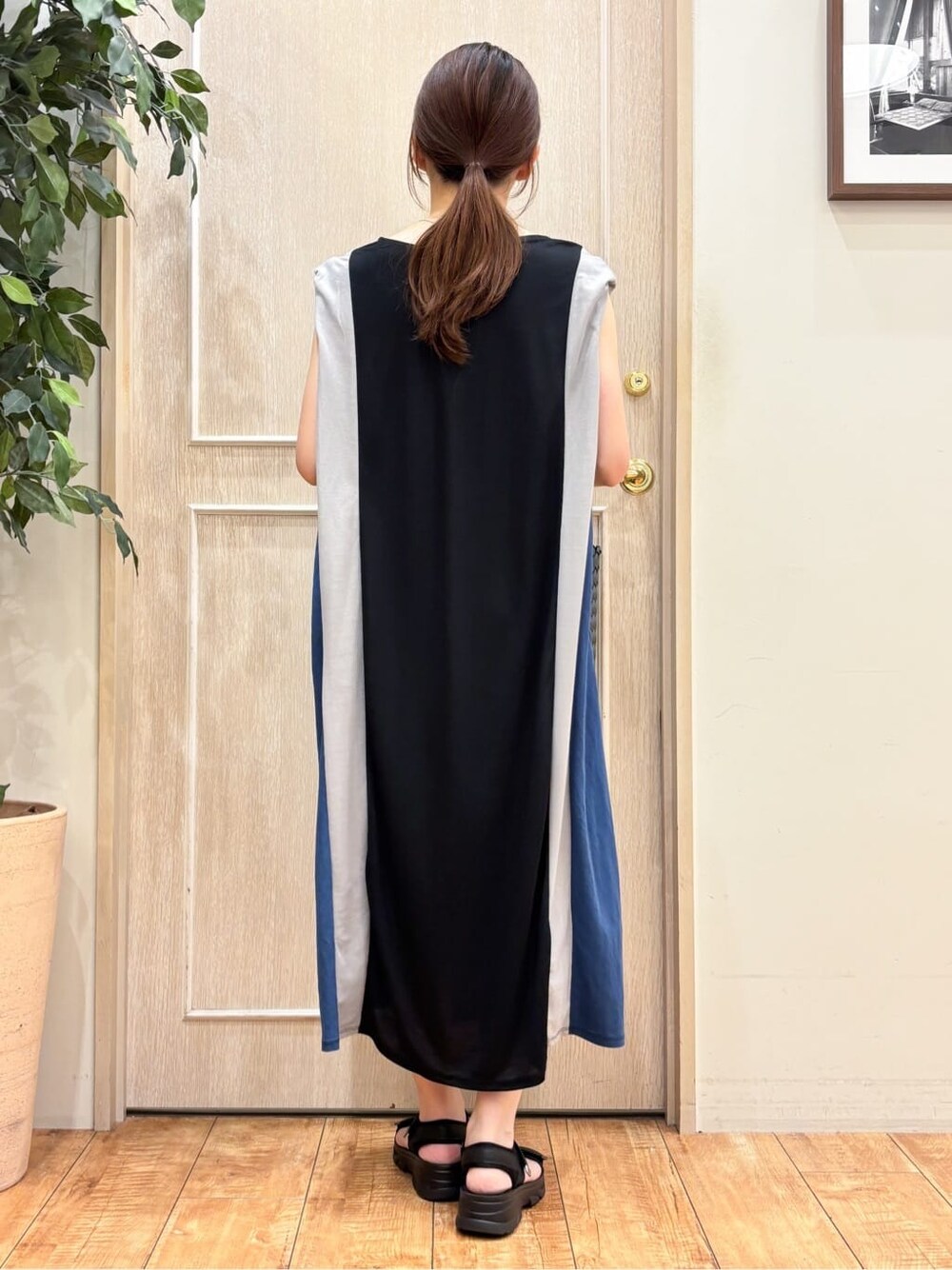 ブラック系のワンピース、ブラック系のサンダル、ブラック系のトートバッグを着用したレディースの夏コーディネートの3枚目の写真