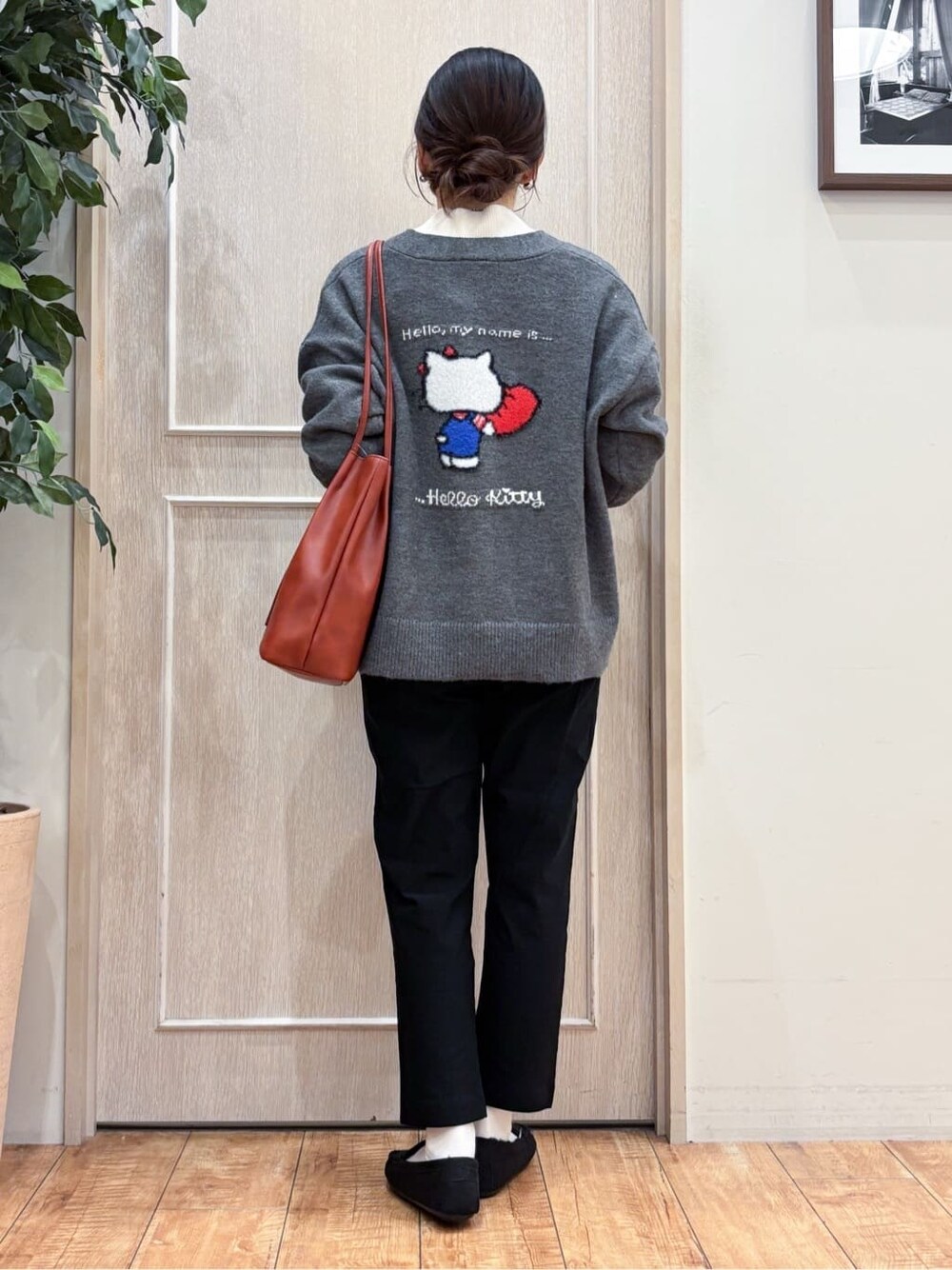 グレー系のカーディガン/ボレロ、ホワイト系のニット/セーター、ブラック系のその他パンツを着用したレディースの冬コーディネートの4枚目の写真