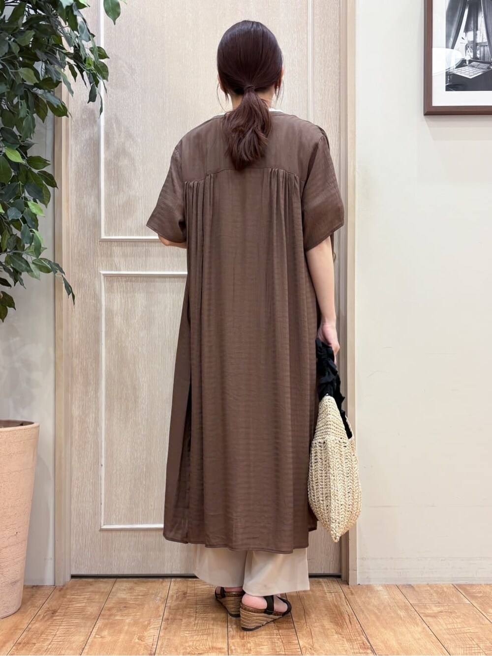 ブラウン系のワンピース、ホワイト系のTシャツ/カットソー、ベージュ系のその他パンツを着用したレディースの夏コーディネートの3枚目の写真