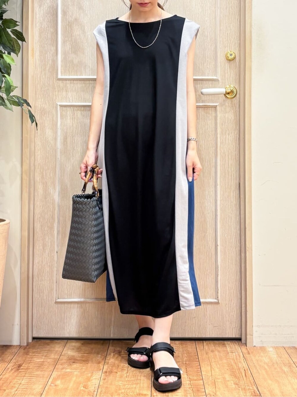 ブラック系のワンピース、ブラック系のサンダル、ブラック系のトートバッグを着用したレディースの夏コーディネートの4枚目の写真