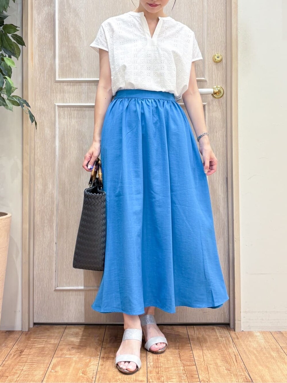 ホワイト系のTシャツ/カットソー、ブルー系のスカート、ブラック系のトートバッグを着用したレディースの夏コーディネートの4枚目の写真