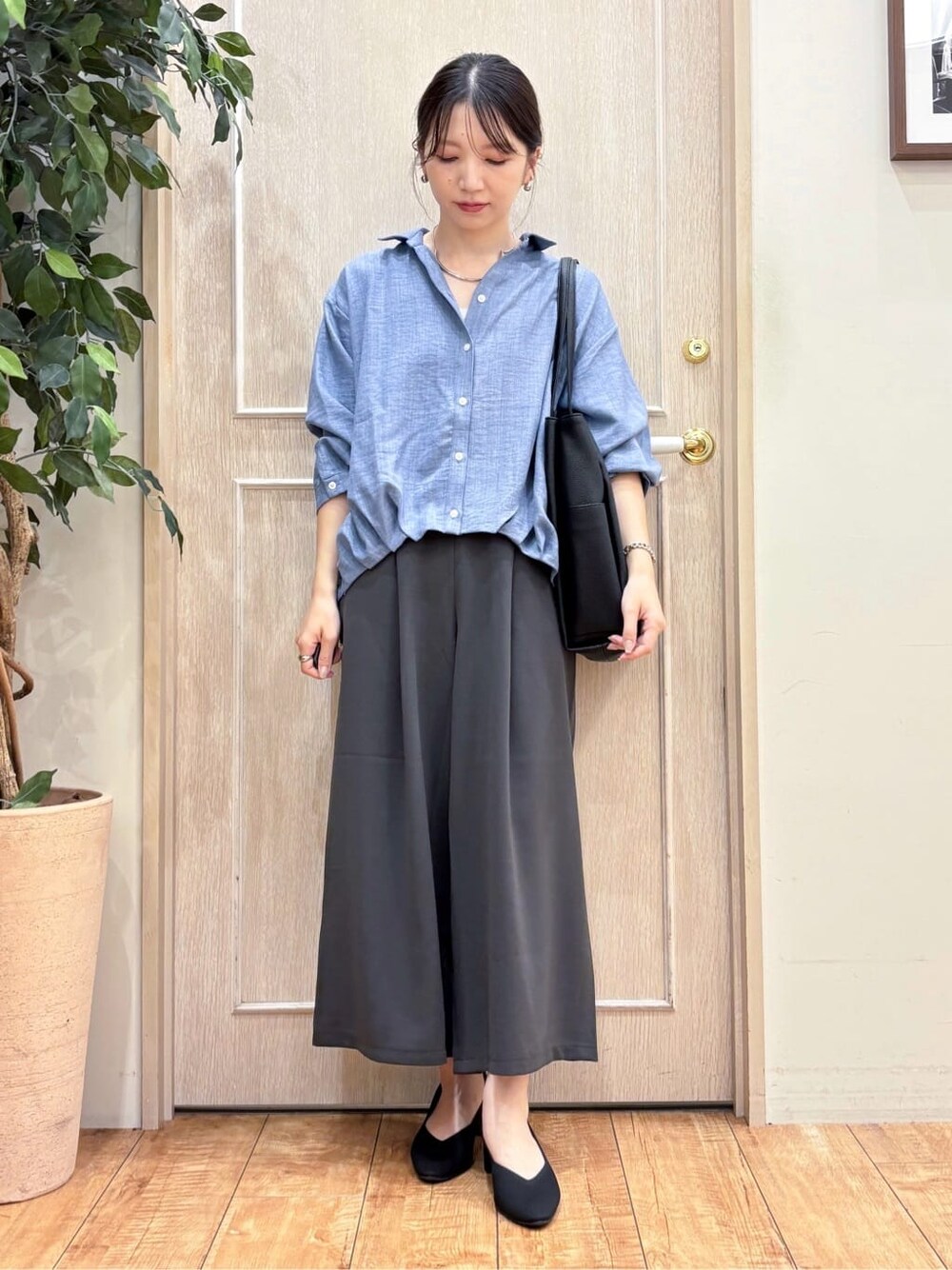ブルー系のシャツ/ブラウス、グレー系のその他パンツ、ブラック系のパンプスを着用したレディースの秋コーディネートの2枚目の写真
