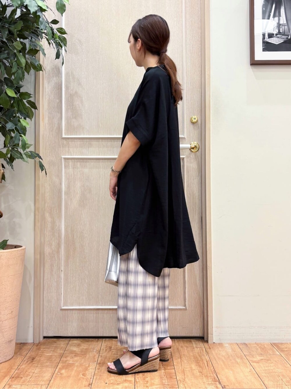 ブラック系のチュニック、グレー系のその他パンツ、ブラック系のサンダルを着用したレディースの夏コーディネートの2枚目の写真