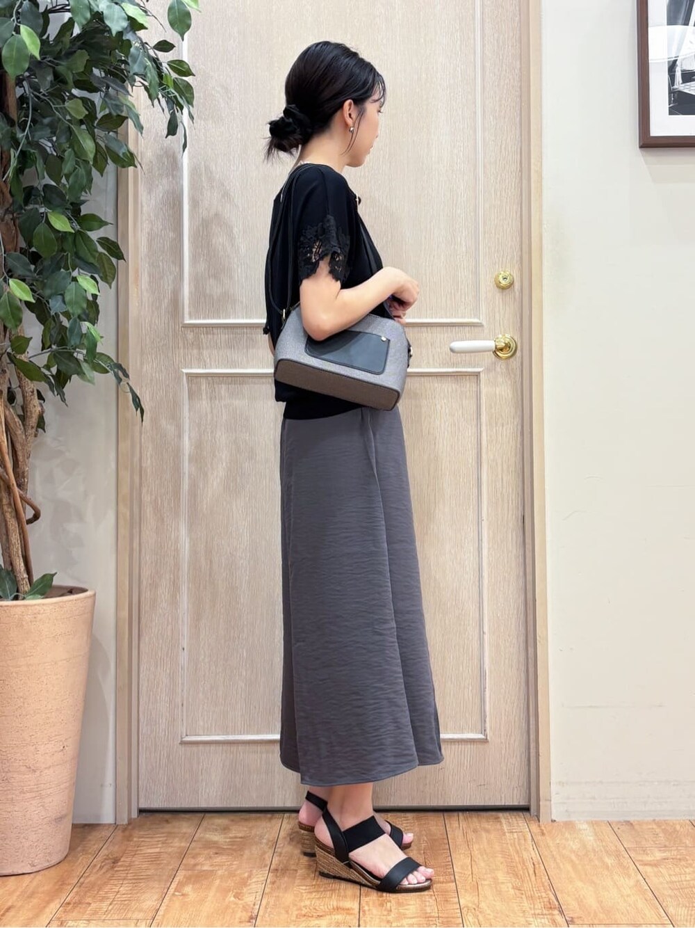 ブラック系のニット/セーター、グレー系のその他パンツ、ブラック系のサンダルを着用したレディースの夏コーディネートの2枚目の写真