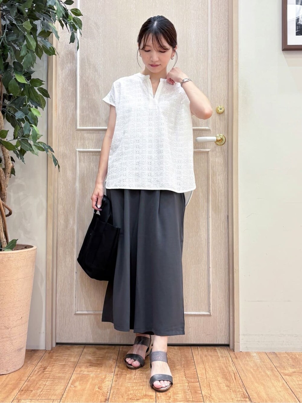 ホワイト系のTシャツ/カットソー、グレー系のその他パンツ、その他のサンダルを着用したレディースの夏コーディネートの2枚目の写真