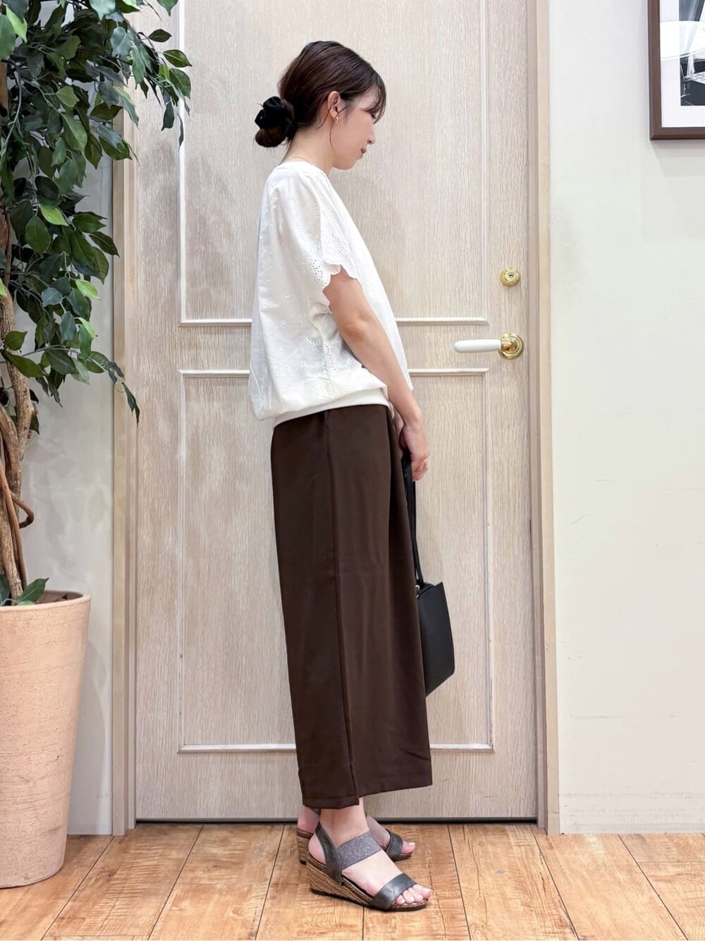 ホワイト系のTシャツ/カットソー、ブラウン系のその他パンツ、その他のサンダルを着用したレディースの夏コーディネートの2枚目の写真