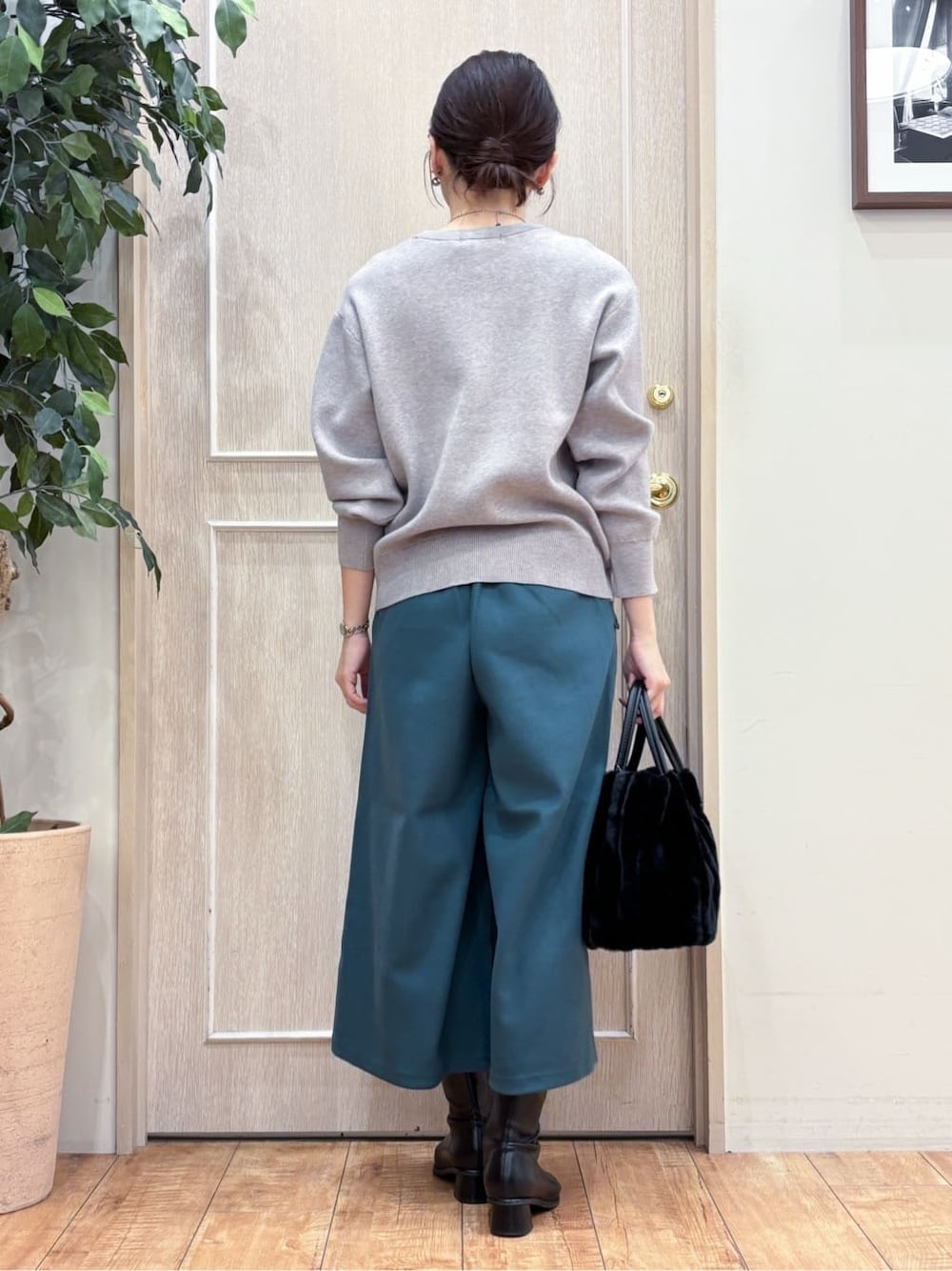 グレー系のニット/セーター、ブラック系のトートバッグ、シルバー系のネックレスを着用したレディースの冬コーディネートの4枚目の写真
