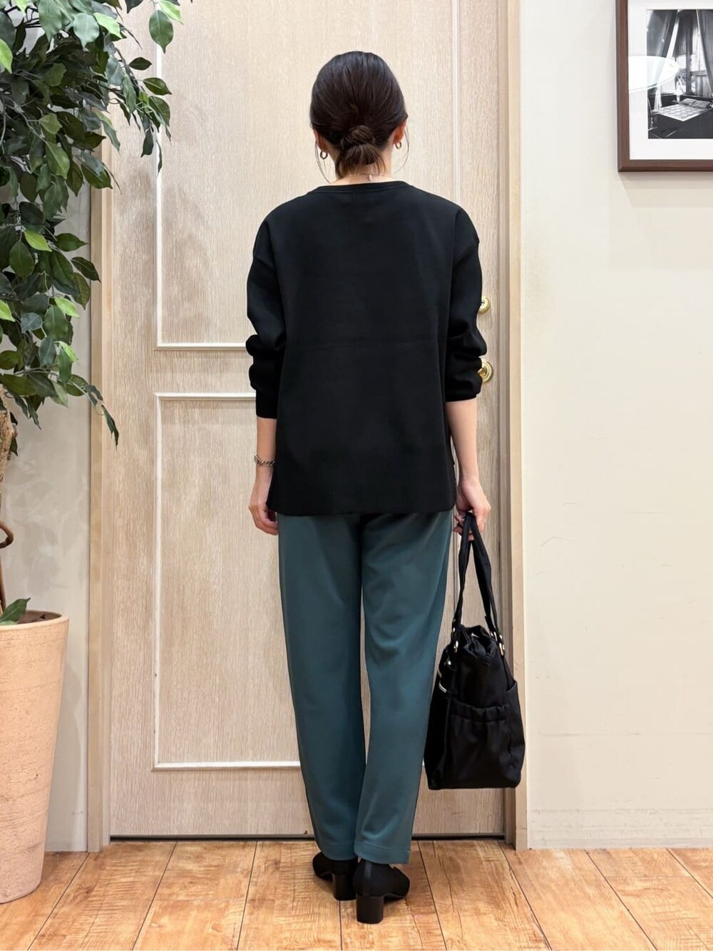ブラック系のニット/セーター、グリーン系のその他パンツ、ブラック系のパンプスを着用したレディースの秋コーディネートの4枚目の写真