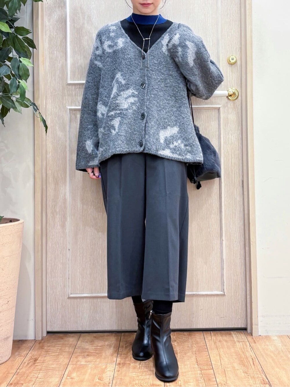 グレー系のカーディガン/ボレロ、ブルー系のニット/セーター、グレー系のその他パンツを着用したレディースの秋コーディネートの4枚目の写真
