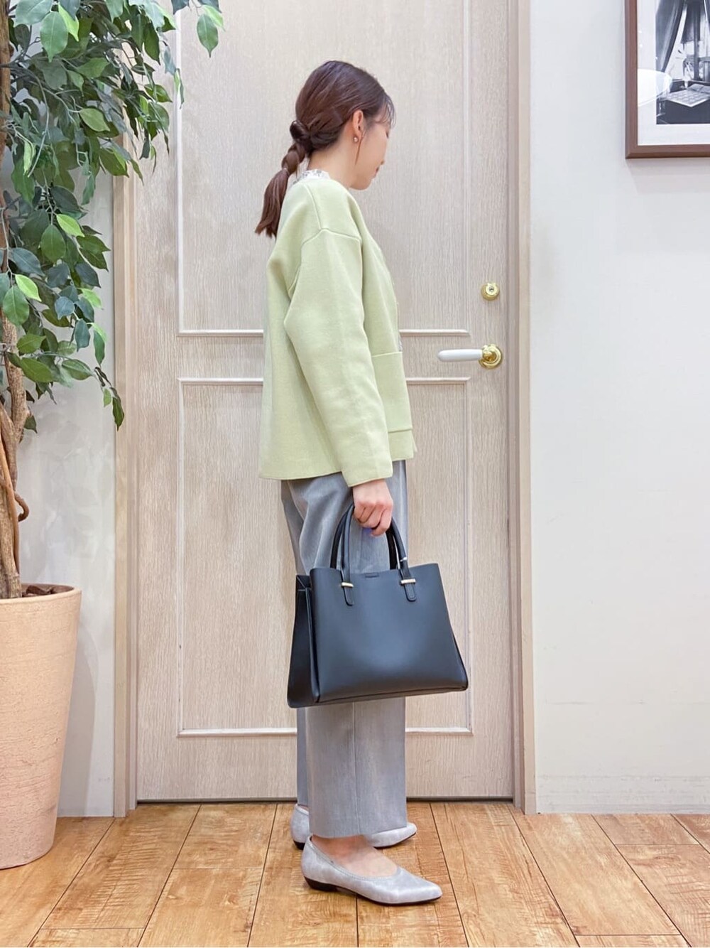 イエロー系のカーディガン/ボレロ、ベージュ系のシャツ/ブラウス、グレー系のその他パンツを着用したレディースの春コーディネートの2枚目の写真