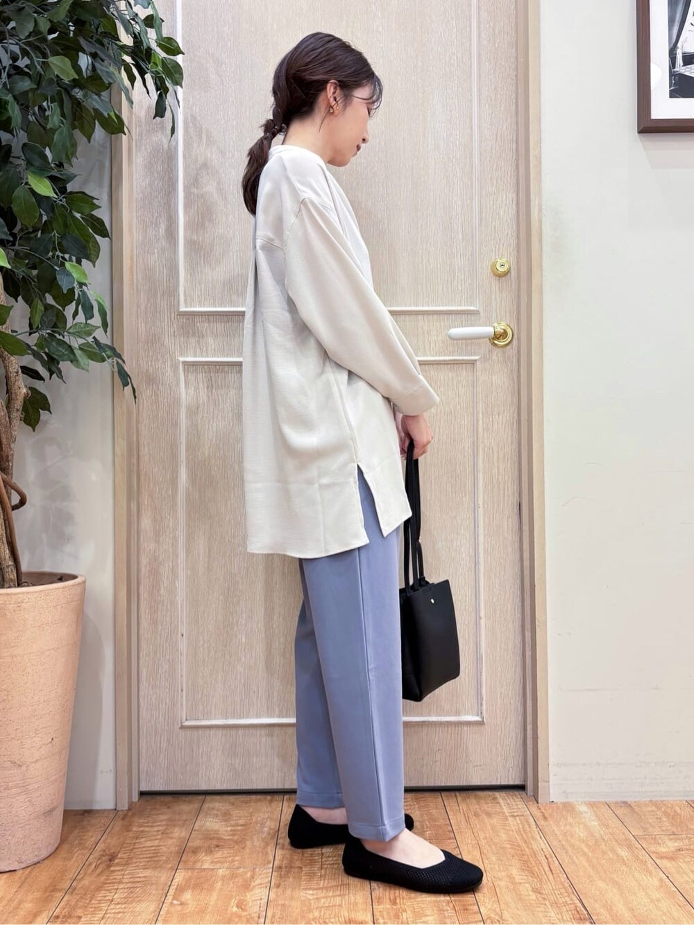 ベージュ系のチュニック、ブルー系のその他パンツ、ブラック系のパンプスを着用したレディースの春コーディネートの3枚目の写真