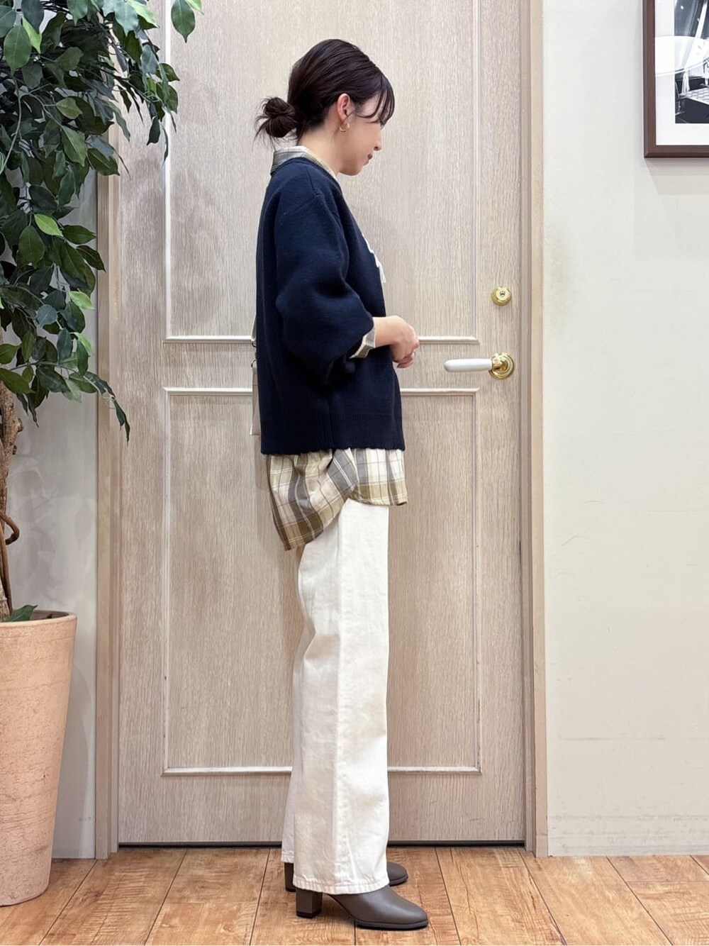 ブルー系のニット/セーター、ベージュ系のシャツ/ブラウス、ホワイト系のデニムパンツを着用したレディースの冬コーディネートの2枚目の写真
